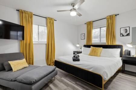 een slaapkamer met een groot bed en een bank bij DFW Stylish Home with Pool Sleeps 9 in North Richland Hills