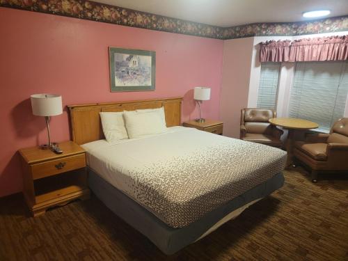 1 dormitorio con 1 cama, 1 silla y 1 mesa en Sweet Breeze Inn, en Grants Pass