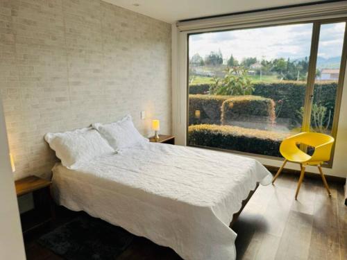 1 dormitorio con cama y ventana grande en Casa de lujo en Paipa Boyacá VIP, en Paipa