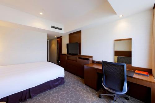 een hotelkamer met een bed, een bureau en een computer bij JR Tower Hotel Nikko Sapporo in Sapporo