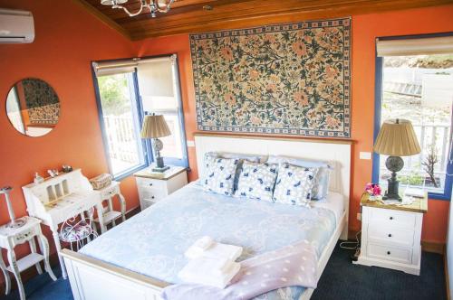 a bedroom with a bed and a tapestry on the wall at Artee House - A Bright Escape in Bright