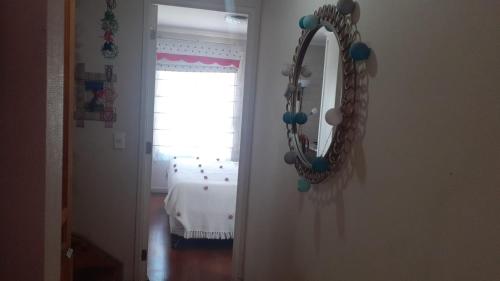 un espejo colgado en una pared en una habitación en 1 habitación comoda, en Santiago