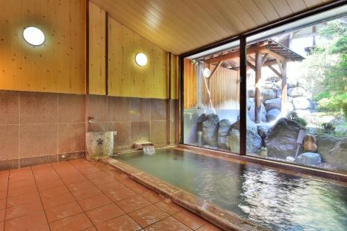 una piscina de agua en una habitación con un acuario en 万葉茶寮みさか en Hirugami