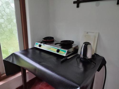 een zwarte tafel met een fornuis met twee pannen erop bij Digital Nomads in Weligama