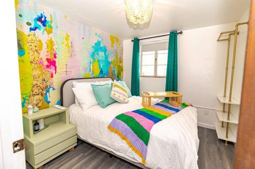 a bedroom with a bed and a colorful wall at *Central 3br Casa Clemente Close UofA & Dtown pets in Tucson