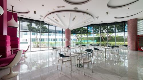 - une salle à manger avec des tables, des chaises et de grandes fenêtres dans l'établissement Great for Staycation for Family in Azure Beach, à Tanza