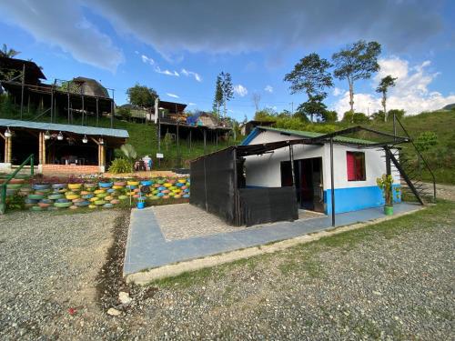 una pequeña casa con techo en un camino de grava en Hotel Glamping Horse, en Dosquebradas