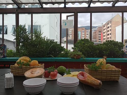 a table with baskets of fruits and vegetables on it at 82Hostel in Bogotá