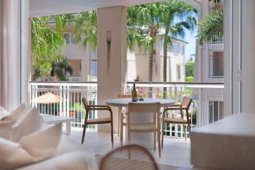 a room with a table and chairs on a balcony at Laguna on Hastings in Noosa Heads