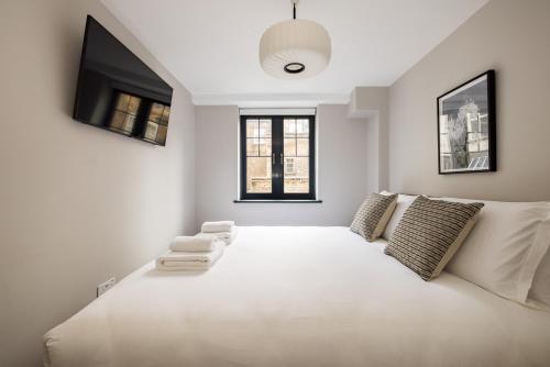 a large white bed in a room with a tv at Covent Garden Apartments in London