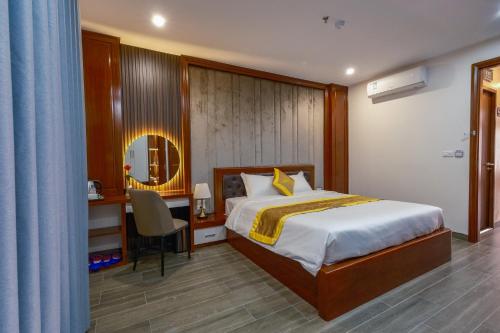 a bedroom with a bed and a desk and a mirror at MIMOSA HOTEL in Ha Long
