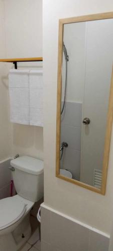 ein Bad mit einem WC und einem Spiegel in der Unterkunft Studio Unit in Mandaluyong in Manila