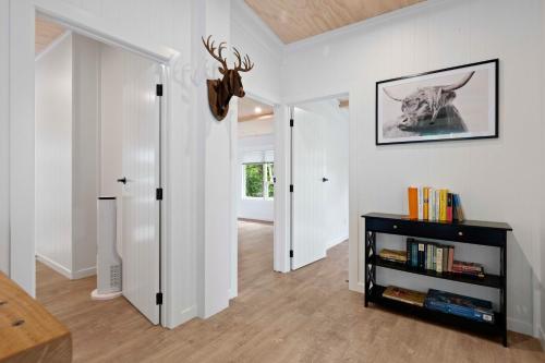 een woonkamer met witte muren en een boekenplank bij Raglan Country Lodge in Raglan
