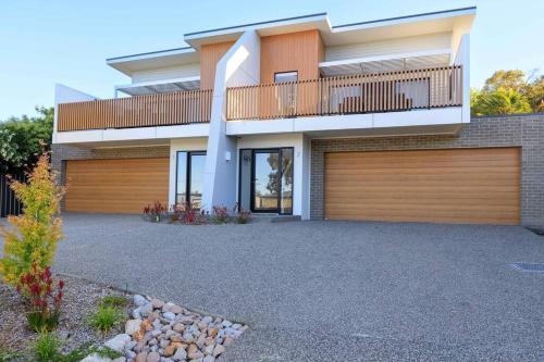 a house with a balcony and a garage at Neddidge Apartment 2 in Albury