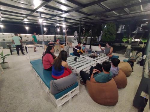 een groep mensen die rond een tafel in het zand zitten bij STAY SUKOON Best Resort in Rishikesh in Rishīkesh