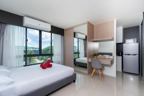 ein Schlafzimmer mit einem Bett und einem Schreibtisch sowie eine Küche in der Unterkunft Central Hill View Condo A920 B with Prime Location in Ban Ket Ho