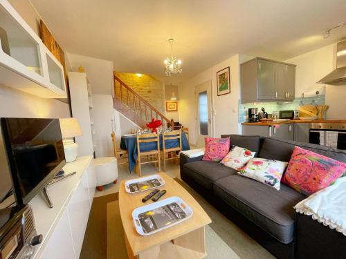 un salon avec un canapé et une table dans l'établissement Gîte tout inclus avec jardin privatif, proche centre Richelieu et châteaux de la Loire - FR-1-381-565, à Richelieu