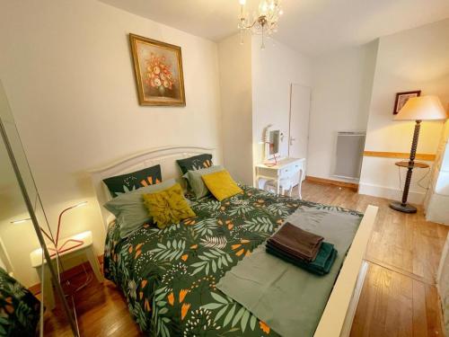 una camera da letto con un letto con un piumone verde di Gîte tout inclus avec jardin privatif, proche centre Richelieu et châteaux de la Loire - FR-1-381-565 a Richelieu