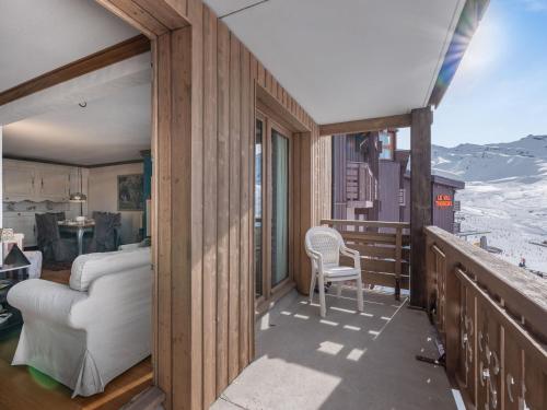 Cette chambre dispose d'un balcon avec un canapé et une chaise. dans l'établissement Appartement 100m² 3 Chambres avec Sauna sur le Front de Neige à Val Thorens - FR-1-640-59, à Val Thorens