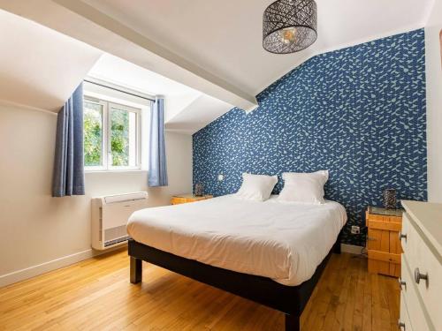 um quarto com uma cama com uma parede azul em Gîte Vichy, 6 pièces, 10 personnes - FR-1-489-494 em Vichy