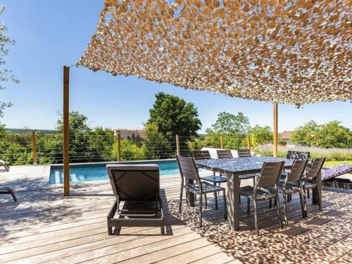 un patio avec une table et des chaises et une piscine dans l'établissement Gîte de charme avec piscine chauffée près des thermes de Vichy, jardin clos, clim et confort absolu - FR-1-489-495, à Vichy