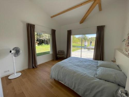 une chambre avec un lit et une grande fenêtre dans l'établissement Villa avec piscine, 10 pers, au calme, climatisée, terrasse, grand jardin - FR-1-379-169, à Soustons