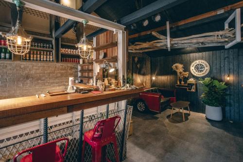 a bar with red chairs and a counter in a room at Original House in Chishang