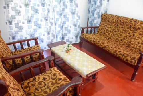a living room with chairs and a table and a couch at Senasuma Holiday Bungalow Anuradhapura in Anuradhapura