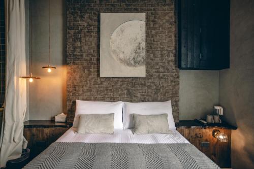 a bed in a bedroom with a brick wall at Original House in Chishang