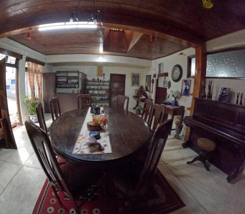 een eetkamer met een tafel en een piano bij Hillgrove homestay in Kurseong