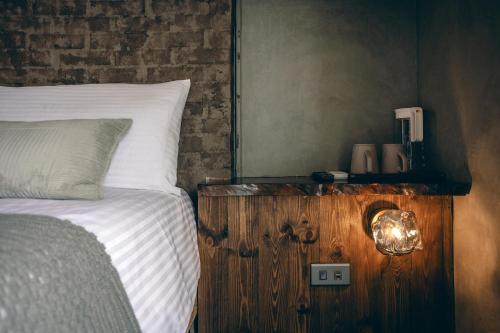 a bedroom with a bed with a wooden night stand with a light on it at Original House in Chishang