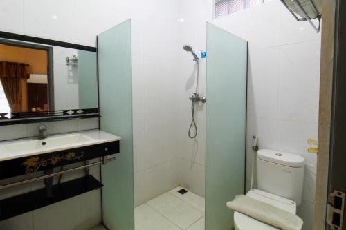 a bathroom with a shower and a toilet and a sink at Sinergi Hotel Tretes in Pasuruan
