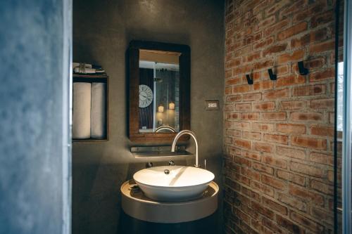 a bathroom with a sink and a brick wall at Original House in Chishang