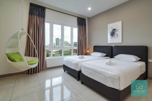 a hotel room with two beds and a window at JOMSTAY Octagon Ipoh Suites in Ipoh
