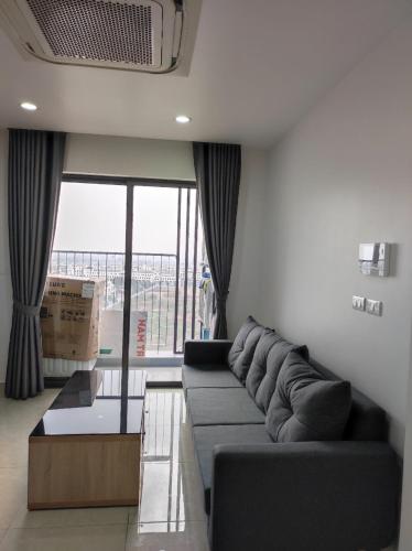 a living room with a couch and a large window at Khu phố Water Front in Hai Phong