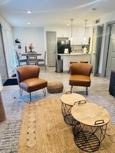 a living room with chairs and tables and a kitchen at Trendy Midtown Apartment in Houston