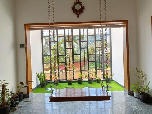 a room with a large window with potted plants at Casa Royal HomeStay in Kattappana