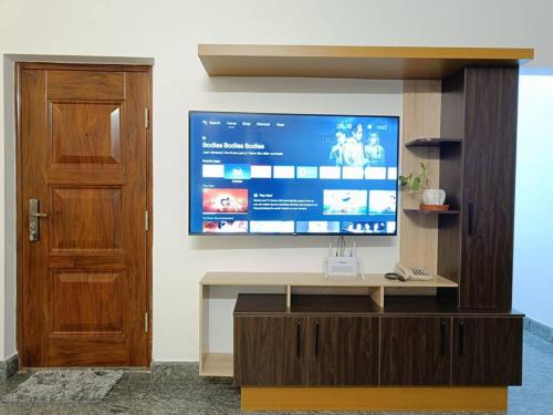 a living room with a large tv on a wall at Casa Royal HomeStay in Kattappana