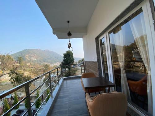 a balcony with a table and chairs and a view at The Aesthetic Hotel & Restaurant in Bhīm Tāl