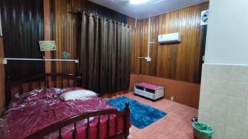 um quarto com uma cama num quarto com paredes de madeira em Nik Legacy Homestay em Pasir Puteh