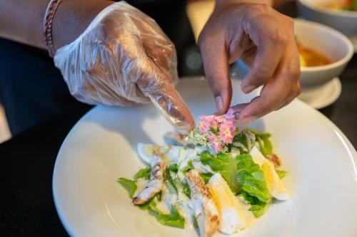 a person is preparing a plate of food at BougainVilla - Oceanfront villa with Cook, ideal for Weddings and Events in Keramas