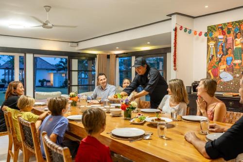a group of people sitting around a table eating at BougainVilla - Oceanfront villa with Cook, ideal for Weddings and Events in Keramas