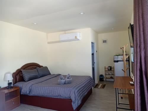a bedroom with a bed with two shoes on it at Home No 3 khanom in Ban Thung O