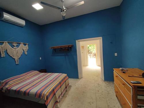 Schlafzimmer mit blauen Wänden, einem Bett und einer Kommode in der Unterkunft Pequeña casa en el centro de Mérida in Azcorra