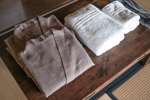 Zwei Handtücher liegen auf einem Holztablett. in der Unterkunft ひねもす101:宇野駅から車で5分 直島へ 最大8名様 古民家 in Tamano