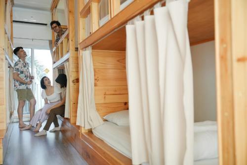 a group of people in a room with bunk beds at Nonnee Hotel Kata Beach Phuket in Kata Beach