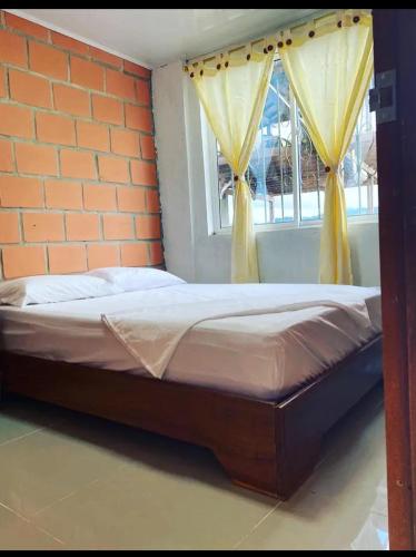 a bed sitting in a room with a window at HOTEL RM in Nuquí