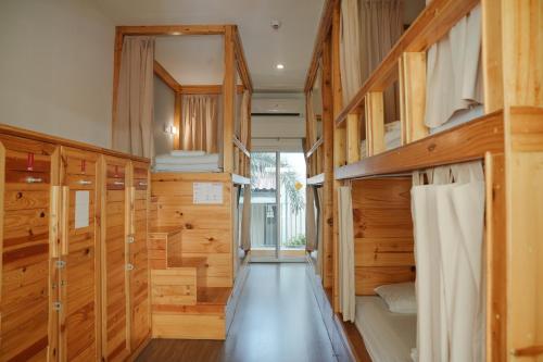 a room with wooden walls and a hallway with bunk beds at Nonnee Hotel Kata Beach Phuket in Kata Beach