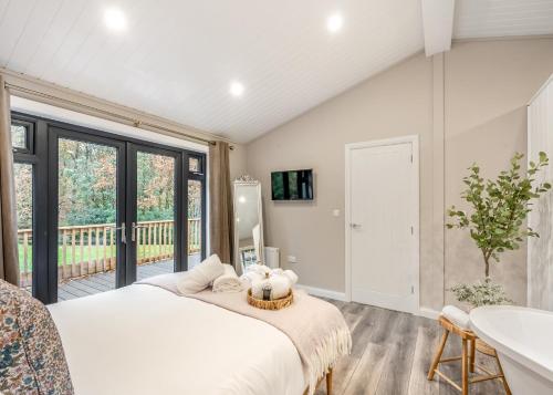 a bedroom with a large bed and a balcony at Charlesworth Lodges in Glossop
