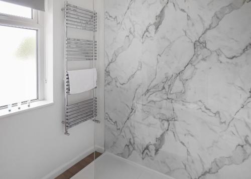 een witte badkamer met een marmeren muur bij Lee Valley in Hoddesdon